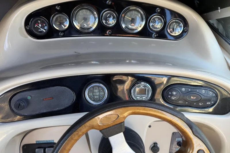 Slide: The Image of Dashboard of a 2001 Sea Ray 260 Sundancer boat with gauges and controls. - 11