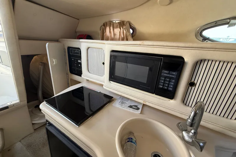 Slide: The Image of 2001 Sea Ray 260 Sundancer cabin interior with kitchenette, microwave, and sink. - 19