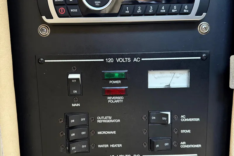 Slide: The Image of Electrical control panel of a 2001 Sea Ray 260 Sundancer boat, showing switches and voltage meter. - 22