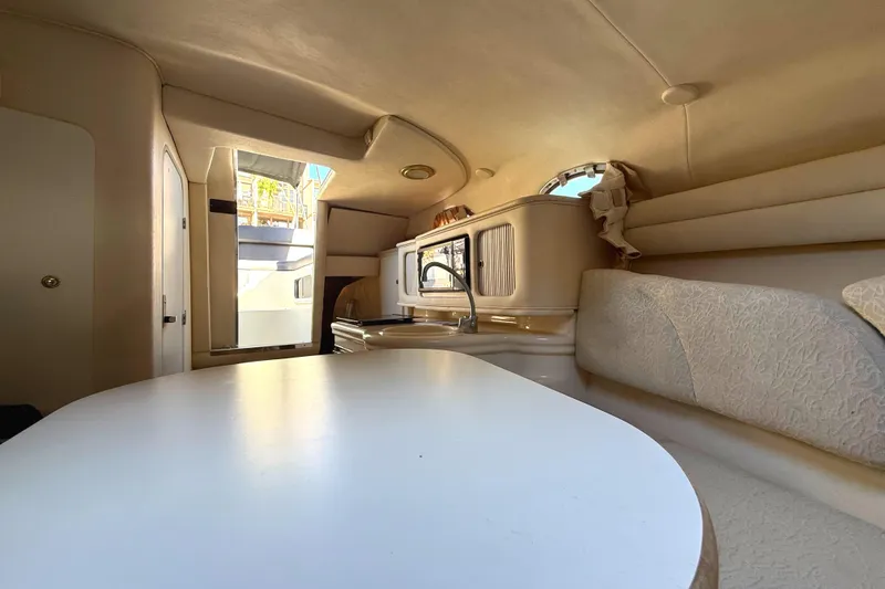 Slide: The Image of Interior of 2001 Sea Ray 260 Sundancer boat, featuring cozy seating and kitchenette. - 28