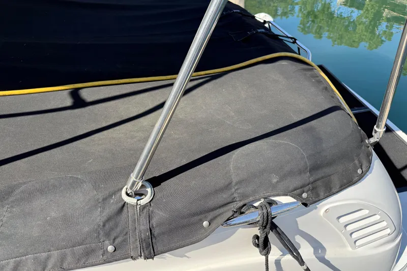 Slide: The Image of 2001 Sea Ray 260 Sundancer boat with black cover and metal supports. - 3