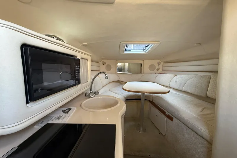 Slide: The Image of Interior of 2001 Sea Ray 260 Sundancer boat with kitchenette and seating area. - 30