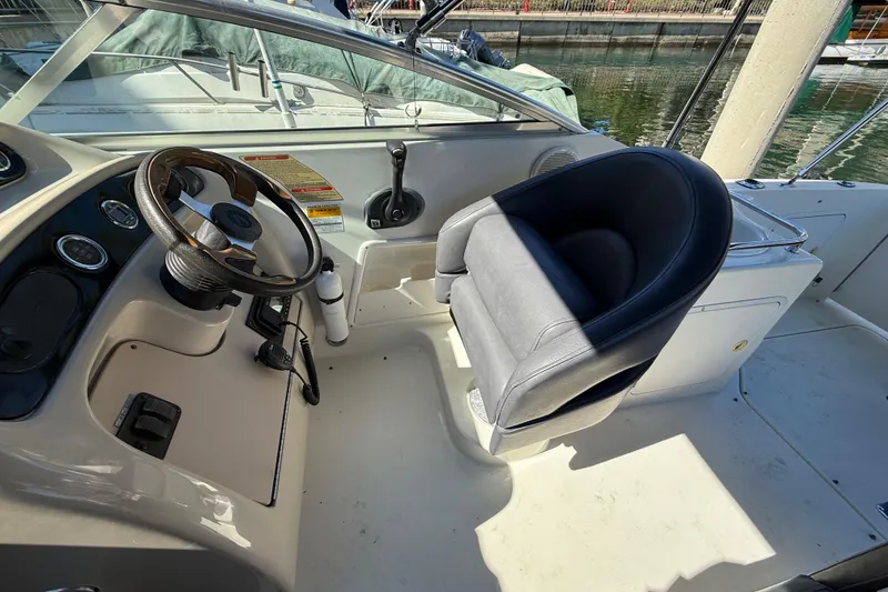 Slide: The Image of 2001 Sea Ray 260 Sundancer cockpit with steering wheel and captain's chair. - 32