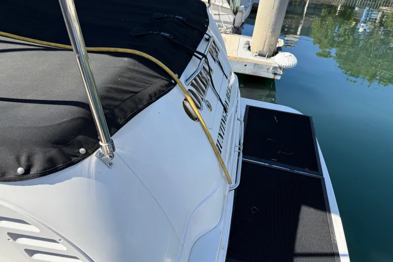 Slide: The Image of 2001 Sea Ray 260 Sundancer docked, featuring a covered deck and marina view. - 4