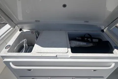 Slide: The Image of 2017 Regulator 31 boat storage compartment with open lid and organized interior. - 17