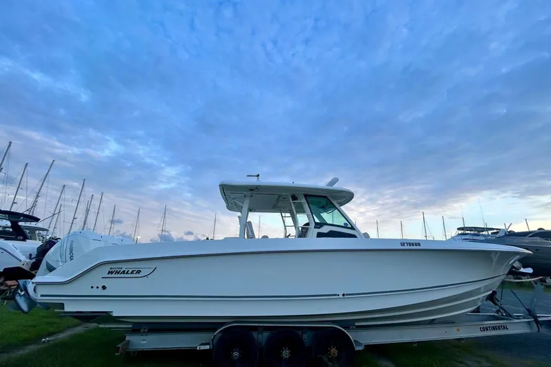 The Image of 2017 Boston Whaler 380 Outrage boat on trailer under a cloudy sky. - 1