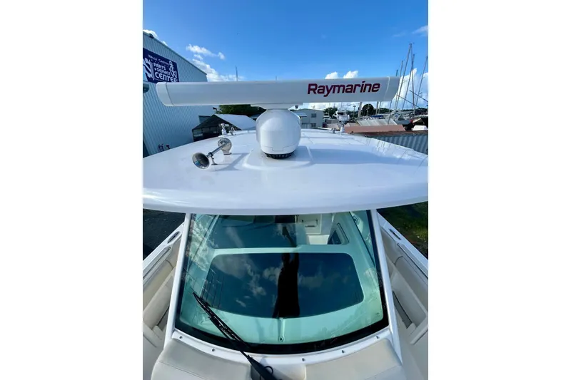 Slide: The Image of 2017 Boston Whaler 380 Outrage with Raymarine radar, docked under clear blue sky. - 10