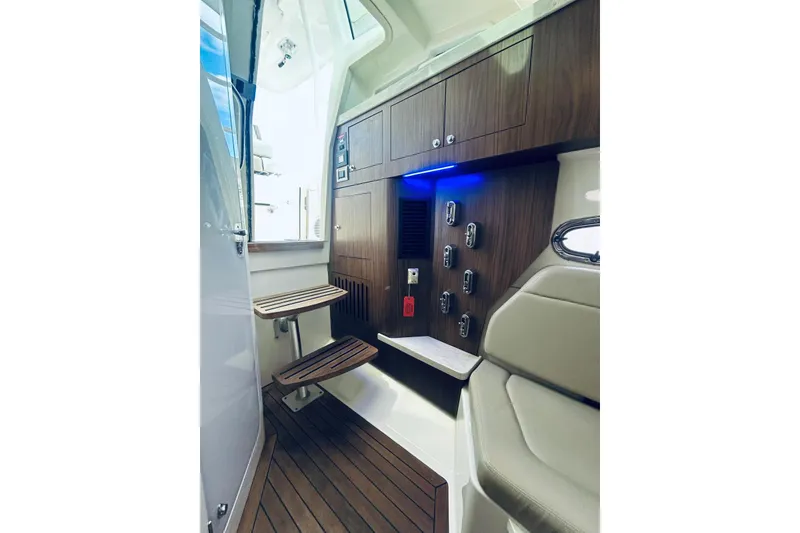 Slide: The Image of Interior of 2017 Boston Whaler 380 Outrage, featuring wood accents and modern controls. - 12