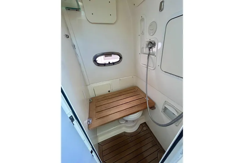 Slide: The Image of 2017 Boston Whaler 380 Outrage bathroom with wooden seat and showerhead. - 14