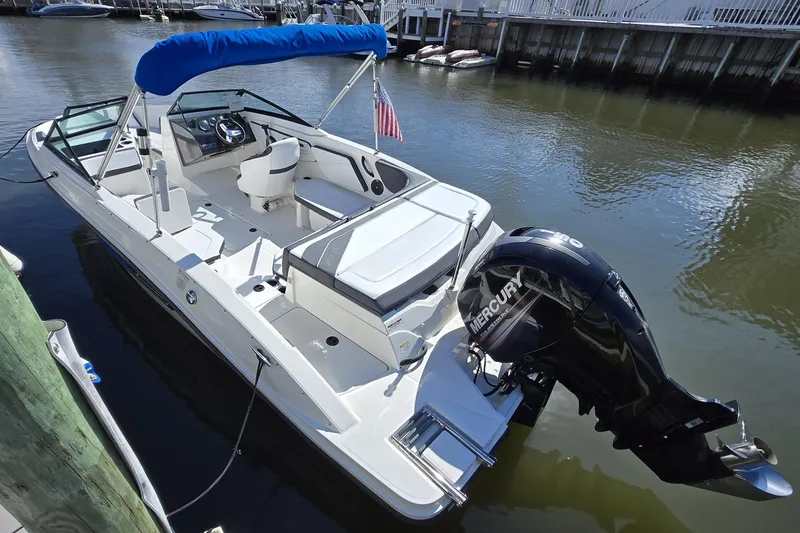 Slide: The Image of 2016 Sea Ray SPX 210 Outboard boat docked, featuring a Mercury engine and blue canopy. - 1