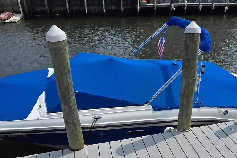 Slide: The Image of 2016 Sea Ray SPX 210 Outboard boat docked with blue cover and American flag. - 7
