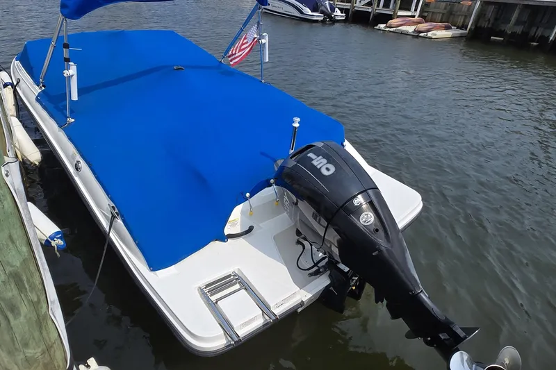 Slide: The Image of 2016 Sea Ray SPX 210 Outboard boat with blue cover docked on water. - 8