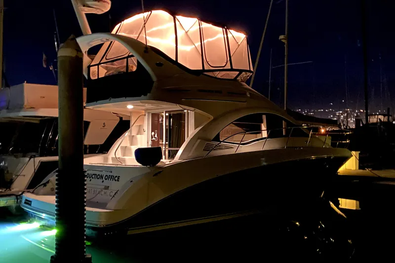 Slide: The Image of 2007 Sea Ray 36 Sedan Bridge yacht illuminated at night in a marina. - 18