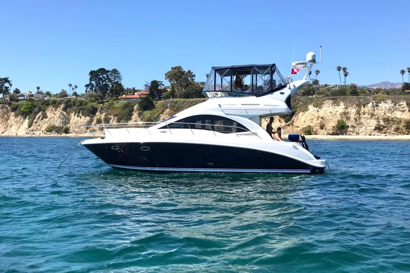 Slide: The Image of 2007 Sea Ray 36 Sedan Bridge yacht docked in a marina under clear blue skies. - 2