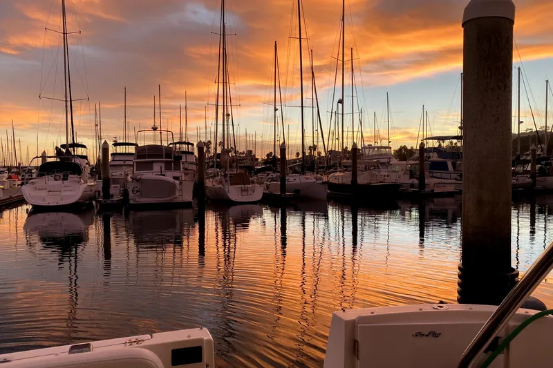 Slide: The Image of Sunset over marina with 2007 Sea Ray 36 Sedan Bridge, sailboats, and vibrant sky reflections. - 21