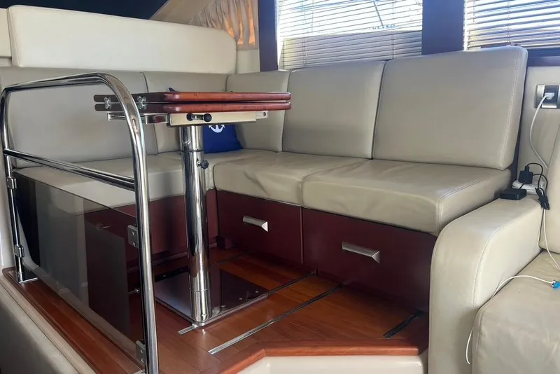 Slide: The Image of Interior of 2007 Sea Ray 36 Sedan Bridge with beige seating and wooden table. - 24
