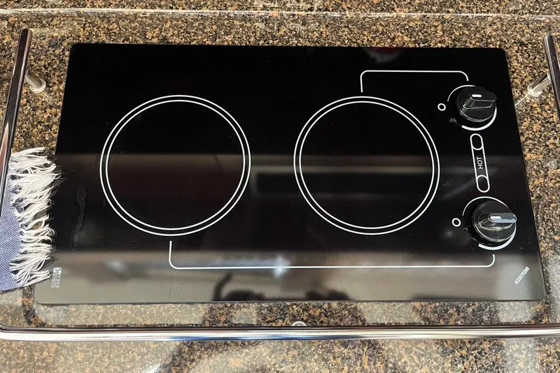 Slide: The Image of Stovetop on 2007 Sea Ray 36 Sedan Bridge yacht, featuring two burners and control knobs. - 27