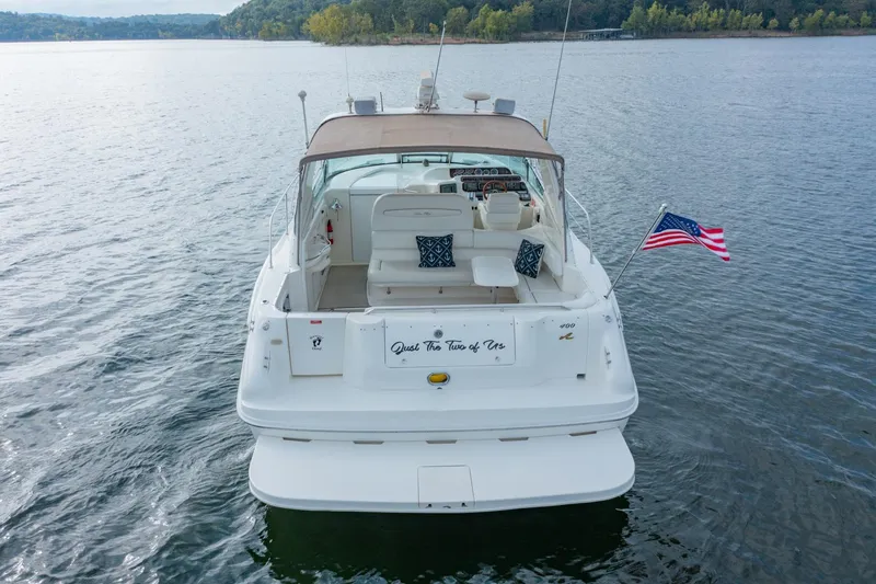 Slide: The Image of 1997 Sea Ray 400 Sundancer yacht on calm water, rear view with American flag. - 5