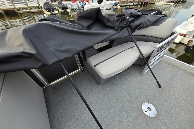 Slide: The Image of 2022 Sylvan L3 Party Fish boat interior with cover partially removed at dock. - 11