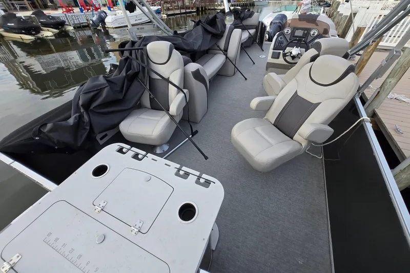 Slide: The Image of 2022 Sylvan L3 Party Fish boat interior with seating and control panel at dock. - 13