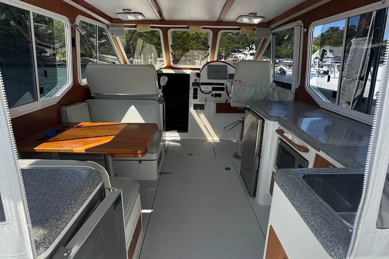 Slide: The Image of Interior of 2004 True North 38 Heritage boat with seating, table, and navigation area. - 10
