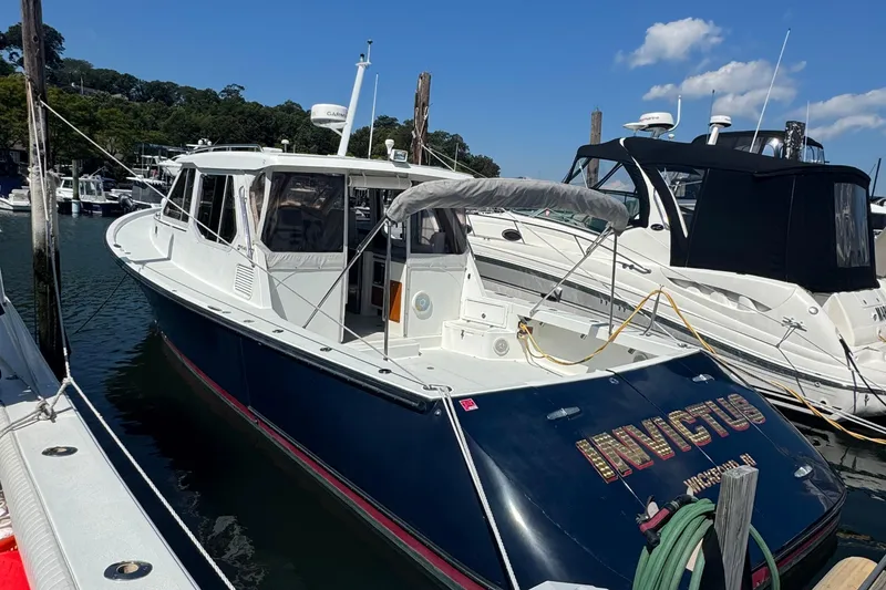 Slide: The Image of 2004 True North 38 Heritage boat docked at marina under clear blue sky. - 2