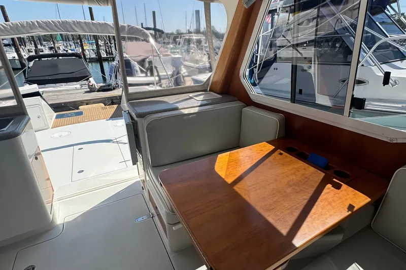 Slide: The Image of Interior of 2004 True North 38 Heritage yacht with wooden table and marina view. - 20