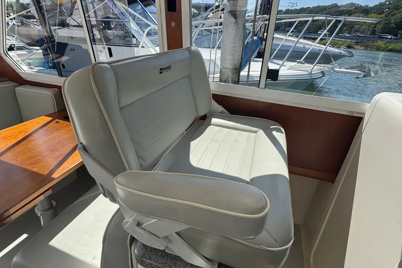 Slide: The Image of Interior of 2004 True North 38 Heritage boat with leather seating and wooden table. - 21