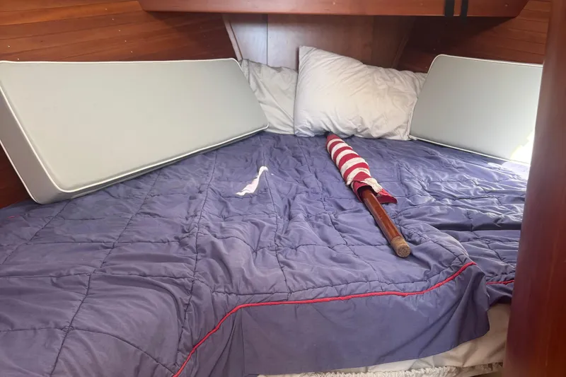Slide: The Image of Cozy cabin bed in 2004 True North 38 Heritage boat with blue bedding and folded flag. - 35