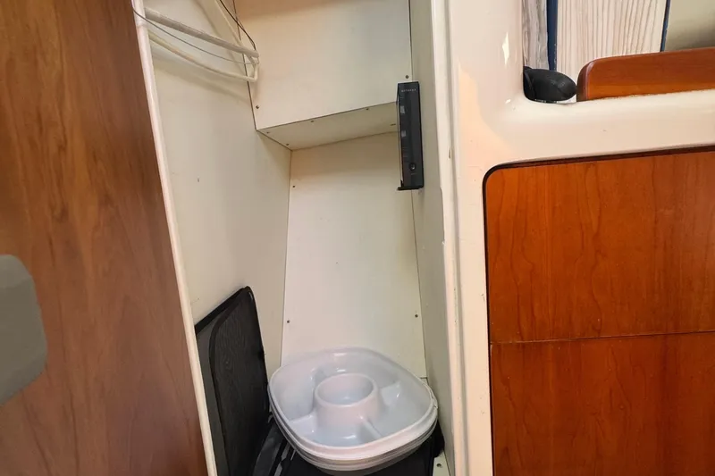 Slide: The Image of Compact storage area in 2004 True North 38 Heritage boat with wooden paneling. - 37