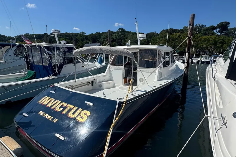 Slide: The Image of 2004 True North 38 Heritage boat docked, named "Invictus," in a marina setting. - 4