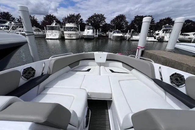 Slide: The Image of 2023 Four Winns H290 boat interior at marina, featuring spacious seating and modern design. - 11