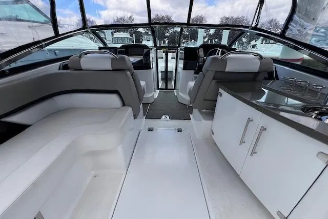 Slide: The Image of 2023 Four Winns H290 boat interior with seating, helm, and kitchenette. - 20