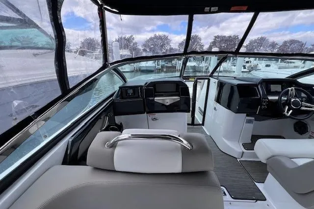 Slide: The Image of Interior view of 2023 Four Winns H290 boat, featuring modern dashboard and seating. - 21