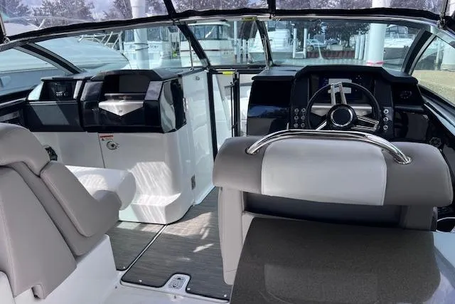 Slide: The Image of 2023 Four Winns H290 boat interior with modern dashboard and seating. - 26
