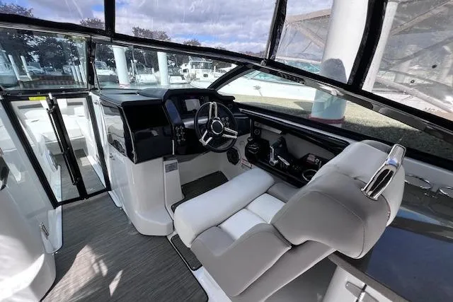 Slide: The Image of Interior of 2023 Four Winns H290 boat, featuring modern helm and seating. - 28