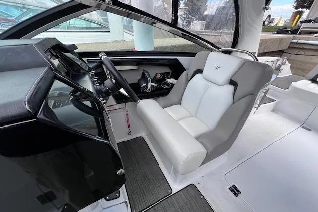 Slide: The Image of 2023 Four Winns H290 boat cockpit with modern steering and comfortable seating. - 32