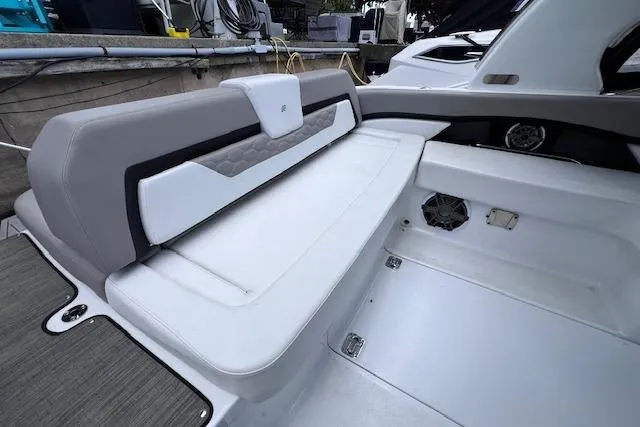 Slide: The Image of 2023 Four Winns H290 boat interior with sleek white seating and modern design. - 40