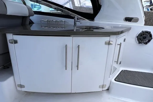 Slide: The Image of 2023 Four Winns H290 boat interior with sleek kitchenette and modern sink design. - 43