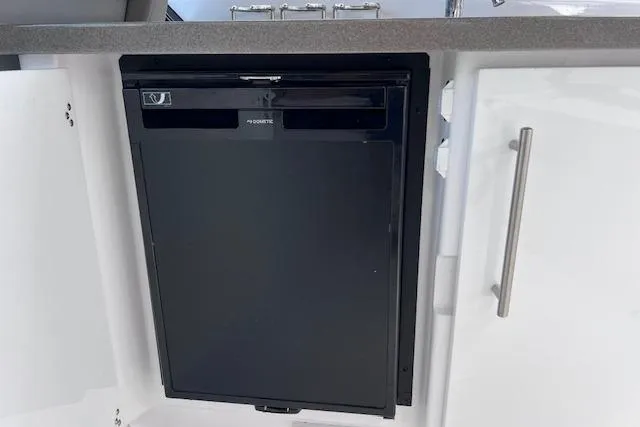 Slide: The Image of Built-in refrigerator on 2023 Four Winns H290 boat, featuring sleek design and modern cabinetry. - 44