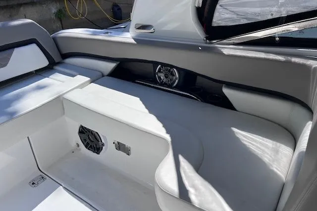 Slide: The Image of 2023 Four Winns H290 boat interior with white seating and built-in speakers. - 46