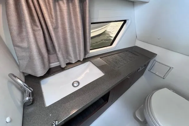 Slide: The Image of 2023 Four Winns H290 boat bathroom with sink, countertop, window, and toilet. - 58