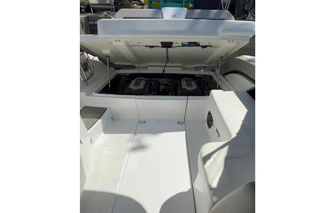Slide: The Image of 2023 Four Winns H290 boat engine compartment with open hatch, showcasing dual engines. - 59