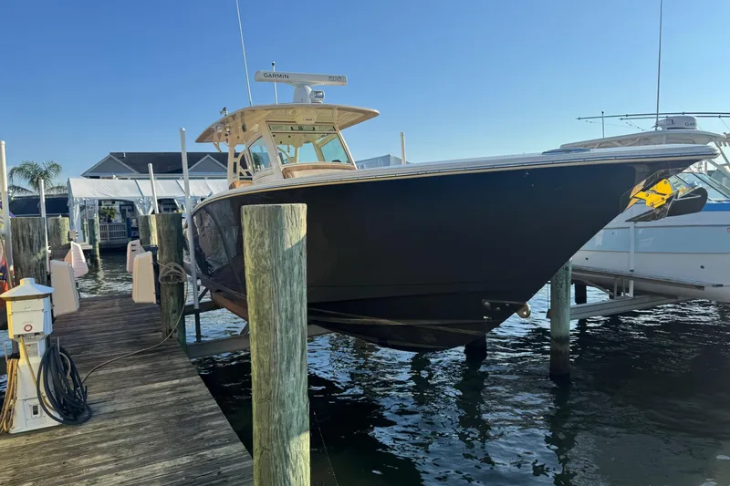 The Image of 2017 Scout 355 LXF boat on a trailer, parked outdoors. - 0