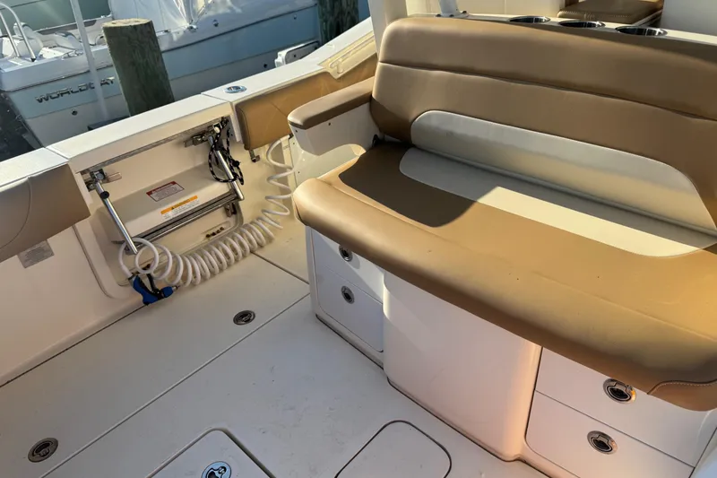 Slide: The Image of 2017 Scout 355 LXF boat interior with tan seating and storage compartments. - 16