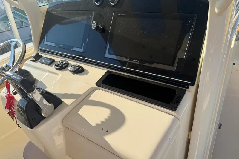 Slide: The Image of 2017 Scout 355 LXF boat dashboard with dual Garmin displays and steering wheel. - 26