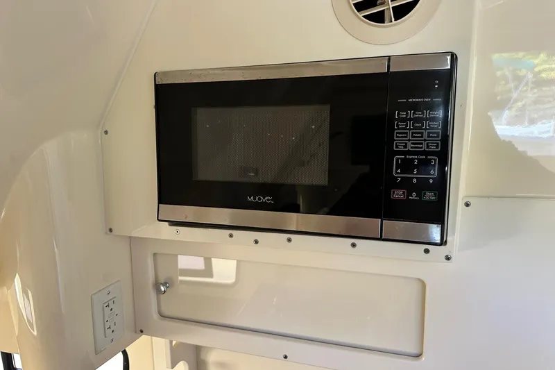 Slide: The Image of Microwave oven inside 2017 Scout 350 LXF boat cabin, featuring control panel and vent. - 32