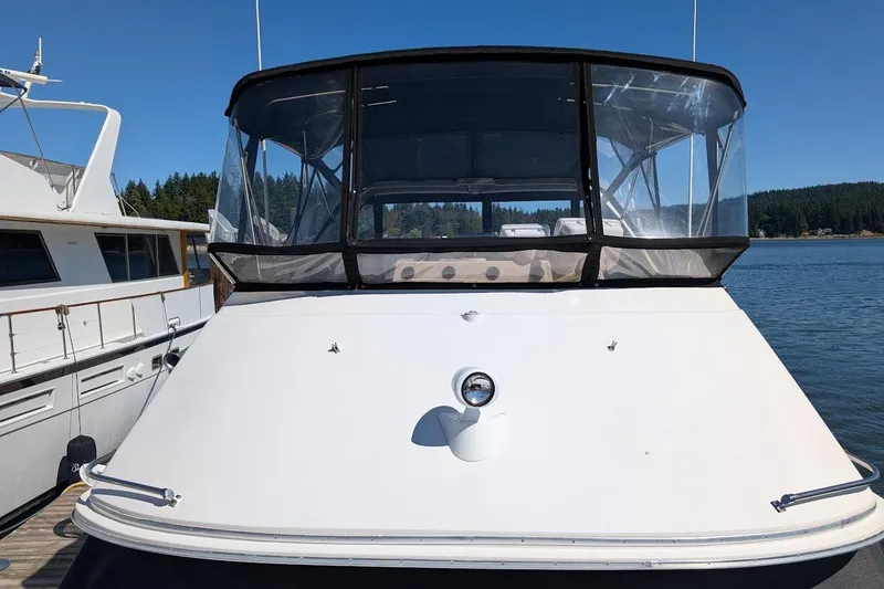 Slide: The Image of 1989 Bayliner 3888 Motoryacht docked, featuring a sleek design and clear canopy. - 10