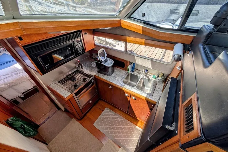 Slide: The Image of 1989 Bayliner 3888 Motoryacht kitchen with stove, microwave, and dual sink. - 14