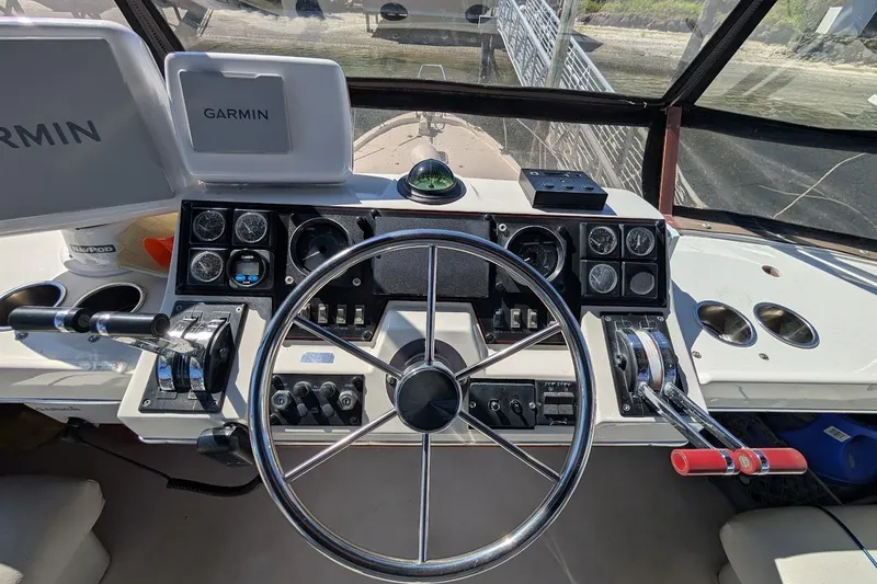 Slide: The Image of 1989 Bayliner 3888 Motoryacht helm with Garmin navigation, steering wheel, and control panel. - 20